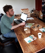 Man aan eettafel achter een laptop